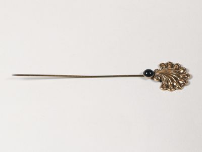 une image représentant une épingle en métal ornée d'une perle noire