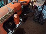 a small orange tractor parked in a garage