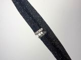 un gros plan sur une ceinture en perles noires avec une boucle argentée