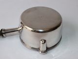a small silver pot with a handle on a white surface