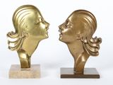 une paire de sculptures en laiton représentant une femme et un homme se faisant face