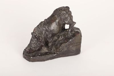 statue en bronze représentant un ours posé sur un rocher, sur fond blanc