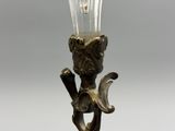 un bougeoir en verre sur lequel est posée une bougie