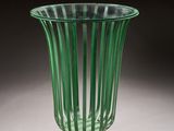 green glass vase sitting on top of a white table