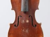 an old violin sitting on top of a white surface
