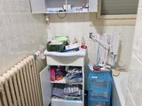 une petite salle de bains avec des toilettes, un lavabo et un meuble de rangement