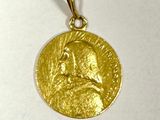 gros plan d'une médaille d'or sur une surface blanche