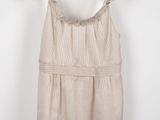 a white top with a ruffled neckline hanging on a hanger
