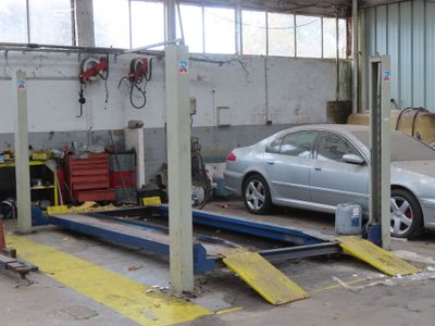 a silver car that is sitting on a lift in a garage
