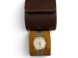an image of a watch sitting on top of a brown case