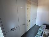 an image of a bedroom with a bed and cupboards