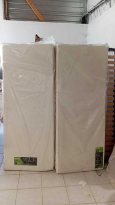 two mattresses stacked on top of each other in a room