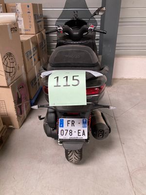 un scooter garé devant des cartons