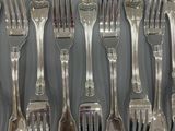 a lot of forks and spoons that are on the table