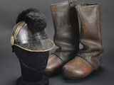 pair of leather boots and a leather hat on a black surface
