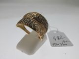 gros plan d'une bague sur une surface blanche avec une étiquette de prix