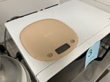 a white box with a tan lid sitting on top of a stove