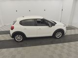 the small white car is parked in the garage