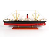 une maquette d'un grand bateau posée sur un socle en bois