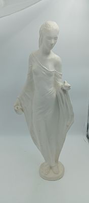 une statue blanche représentant une femme debout à côté d'une horloge