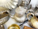 de nombreux modèles différents de théières en argent posées sur une table