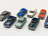 several toy cars are lined up in a row on a white surface
