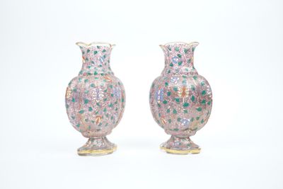 une paire de vases roses et verts posés sur une surface blanche