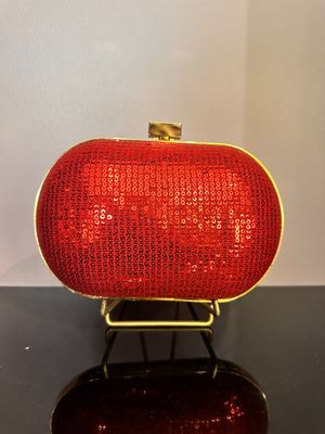 Le sac à main rouge est posé sur une table noire.