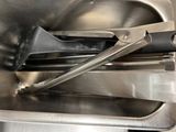 a close up of a metal container with tongs inside of it