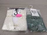 two pairs of white and green sweaters are wrapped in plastic bags