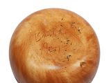 a wooden ball with writing on it on a white surface