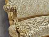 a gold colored couch with a white and gold pattern on it