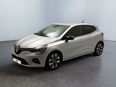 Une voiture argentée est garée dans une pièce blanche au sol noir.