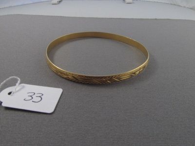 un bracelet en or avec une étiquette de prix posé sur un lit
