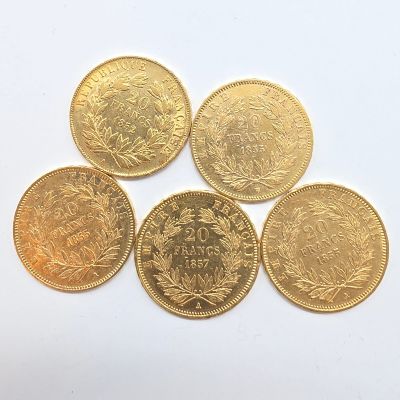 cinq pièces d'or sur lesquelles figurent les noms de différents pays