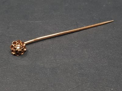 un gros plan sur un bâton plaqué or orné d'une fleur