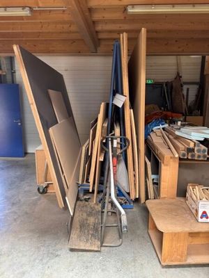 plusieurs morceaux de bois sont empilés sur une charrette dans un garage