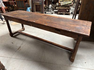 un long banc en bois situé dans une pièce où se trouvent de nombreux meubles