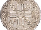 an old silver coin with a cross and crown on it