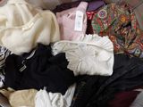 a pile of clothes sitting in a basket on the floor
