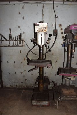 une photo d'une perceuse et d'une perceuse à colonne dans un garage