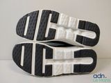 the soles of a pair of black and white running shoes
