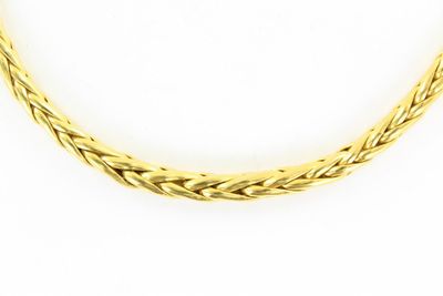 gros plan d'un collier en or sur fond blanc
