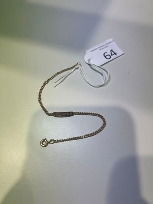 un collier en argent avec un fermoir en or posé sur une table