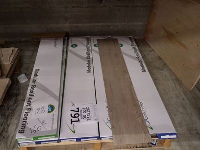 several boxes of wood sit on a pallet in a warehouse
