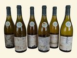 six bottles of wine are lined up in a row on a table