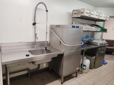 une cuisine équipée d'éviers en inox et d'un évier avec un robinet