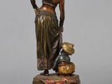 bronze statue of a woman with a basket and a cat