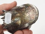 a hand holding a silver object with a tag on it