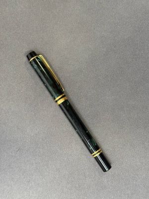 un stylo posé sur une table, à côté d'une tasse de café